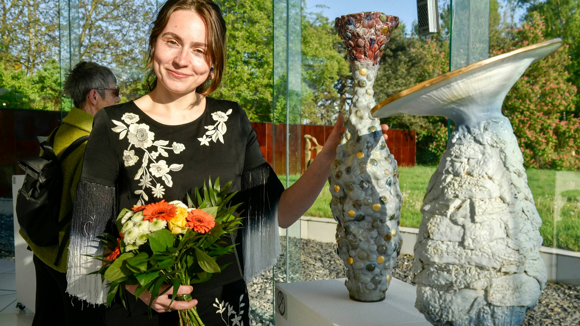 Auf dem Bild ist die Sonderpreisträgerin vor einigen ihrer Objekte zu sehen.