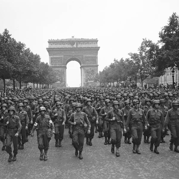 Amerikanische Truppen marschieren nach der Befreiung der französischen Hauptstadt über den Champs Elysees, im Hintergrund ist der Arc de Triomphe zu sehen.