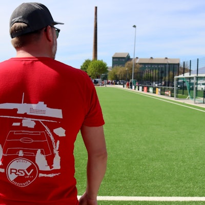 Die Rückseite eines T-Shirts zeigt die Silhouette der Arloffer Thonwerke, die im Hintergrund in natura zu sehen sind.