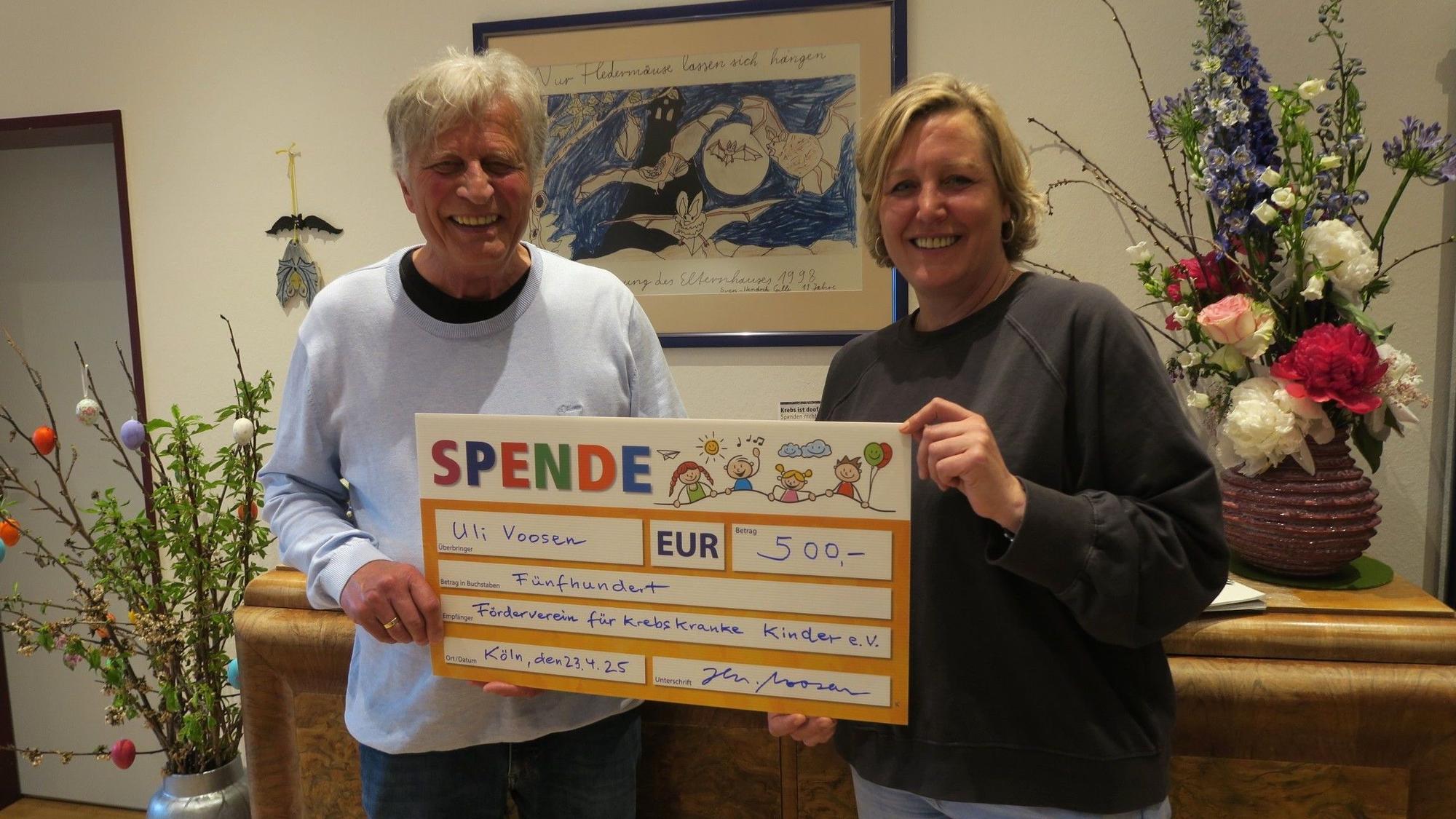 Ein Mann und eine Frau halten gemeinsam einen gemalten überdimensionierten Scheck über 500 Euro hoch.