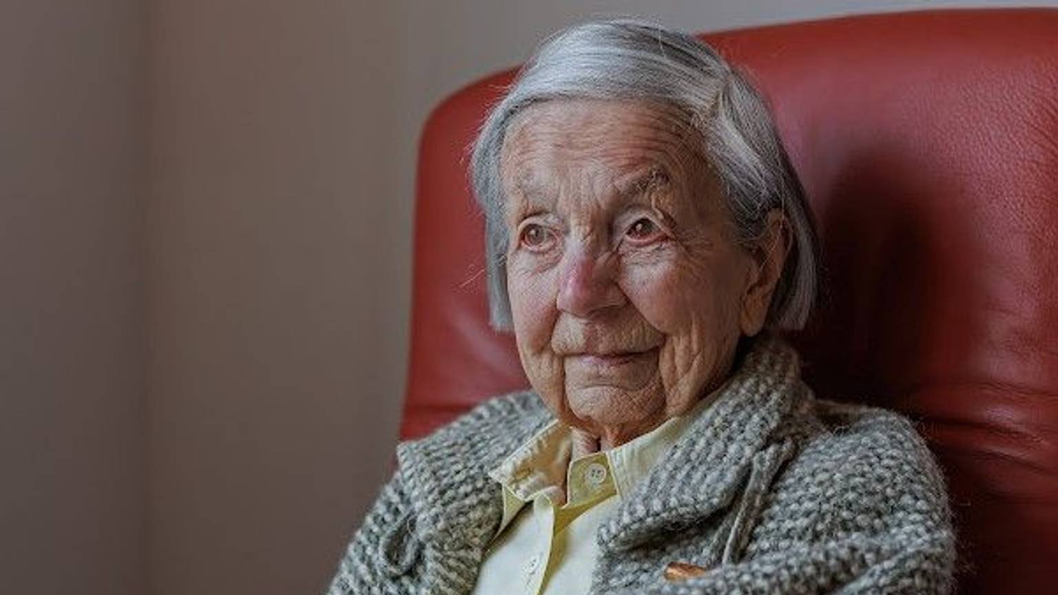 Eva Doering sitzt in der Nahaufnahme ihres Gesichts und Schulterbereichs auf einem roten Sessel.
