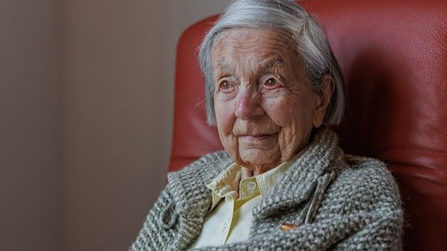 Eva Doering sitzt in der Nahaufnahme ihres Gesichts und Schulterbereichs auf einem roten Sessel.