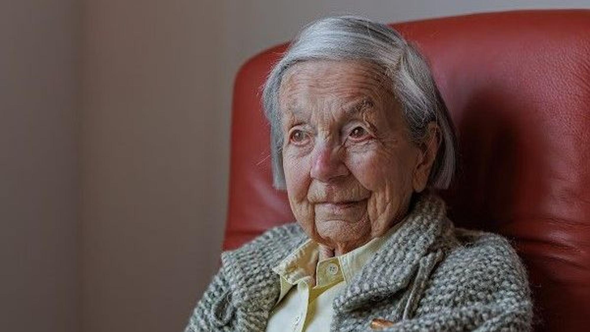 Eva Doering sitzt in der Nahaufnahme ihres Gesichts und Schulterbereichs auf einem roten Sessel.