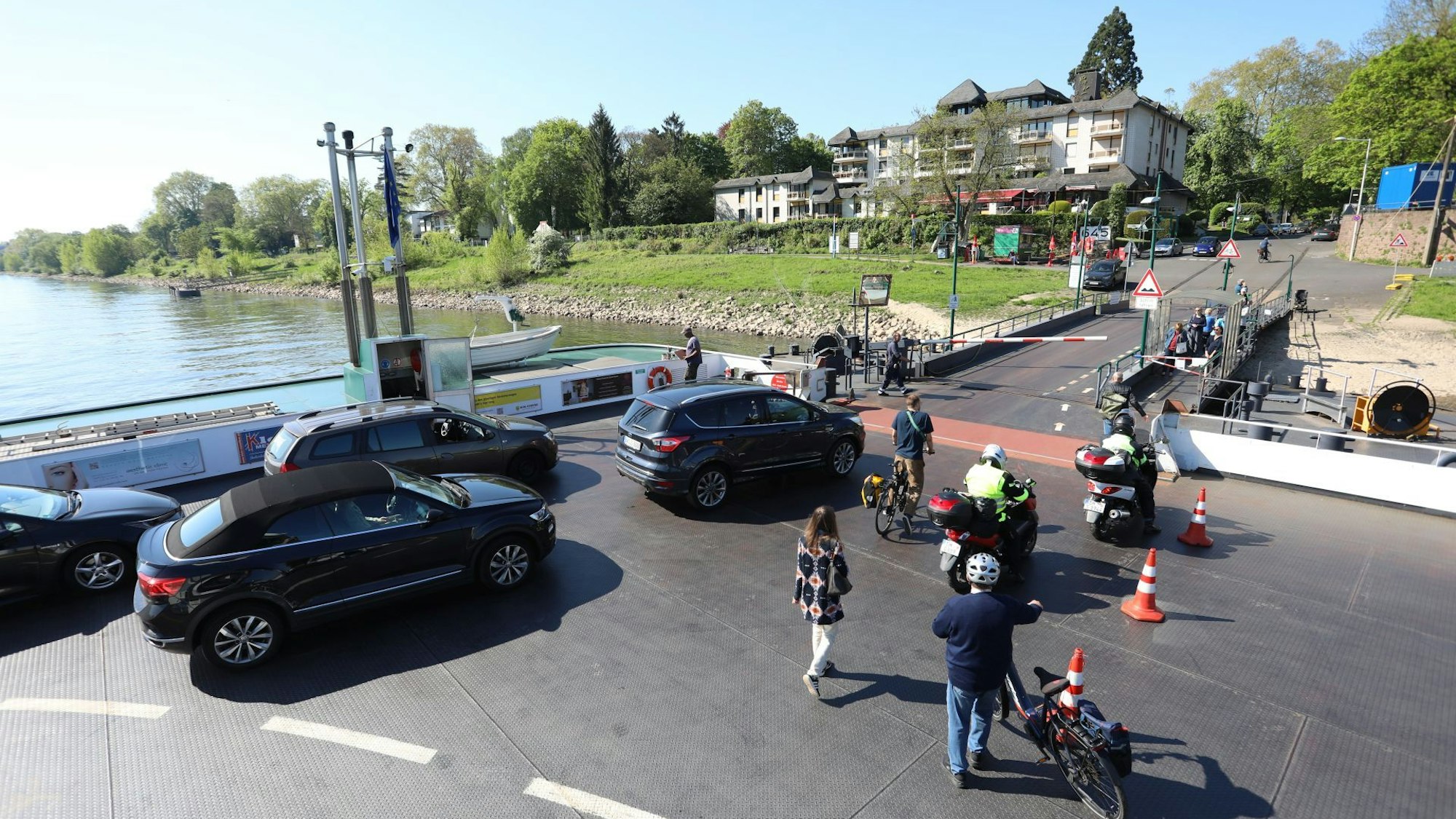 Fahrzeuge, Radfahrer und Fußgänger verlassen eine Fähre