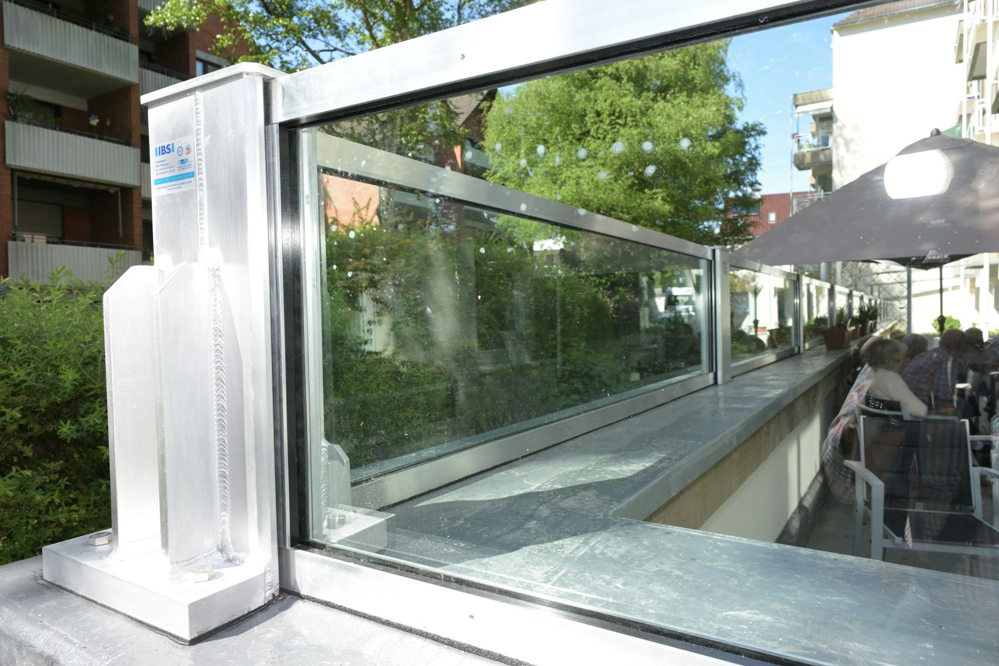 Eine Glasbarriere schützt einen Platz im Freien und Terrassentüren.