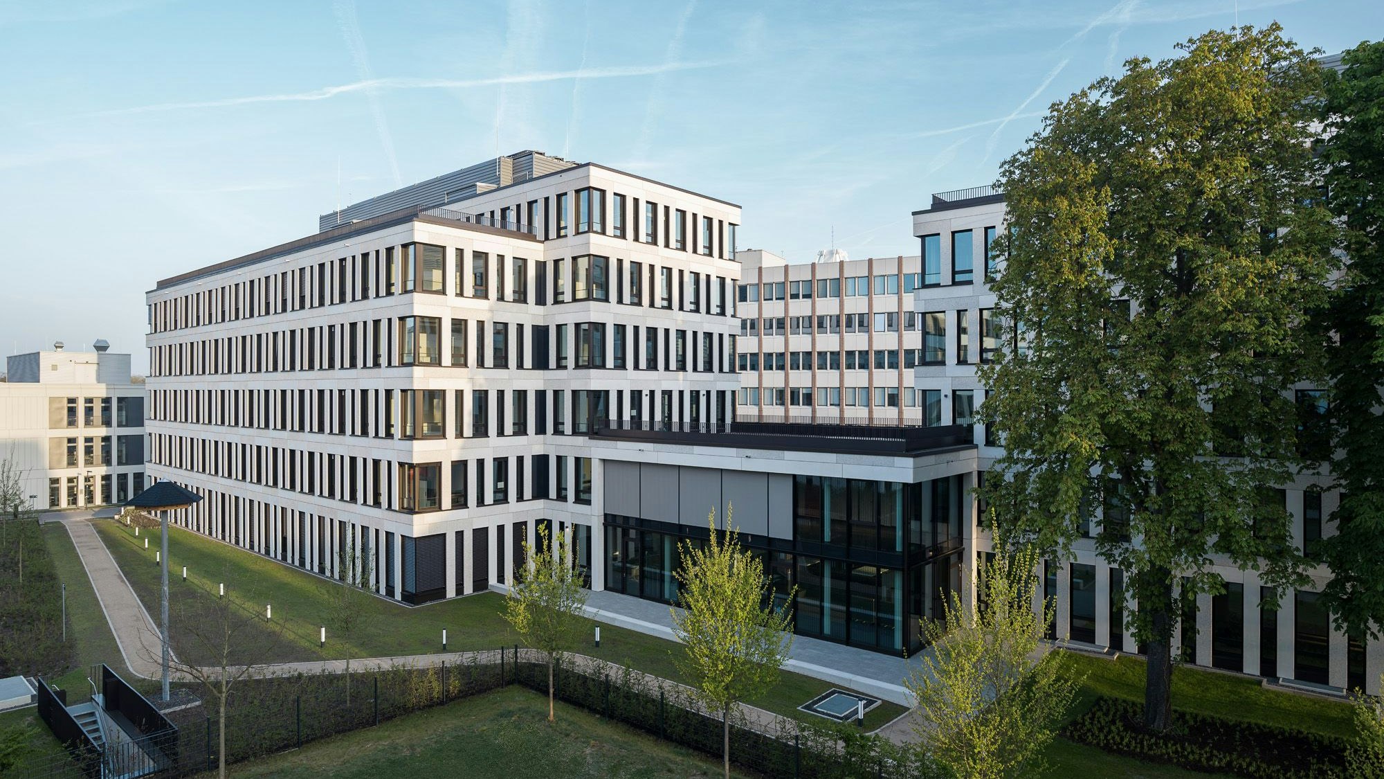 Ein neues mehrgeschossiges Bürogebäude steht an einer Straße.