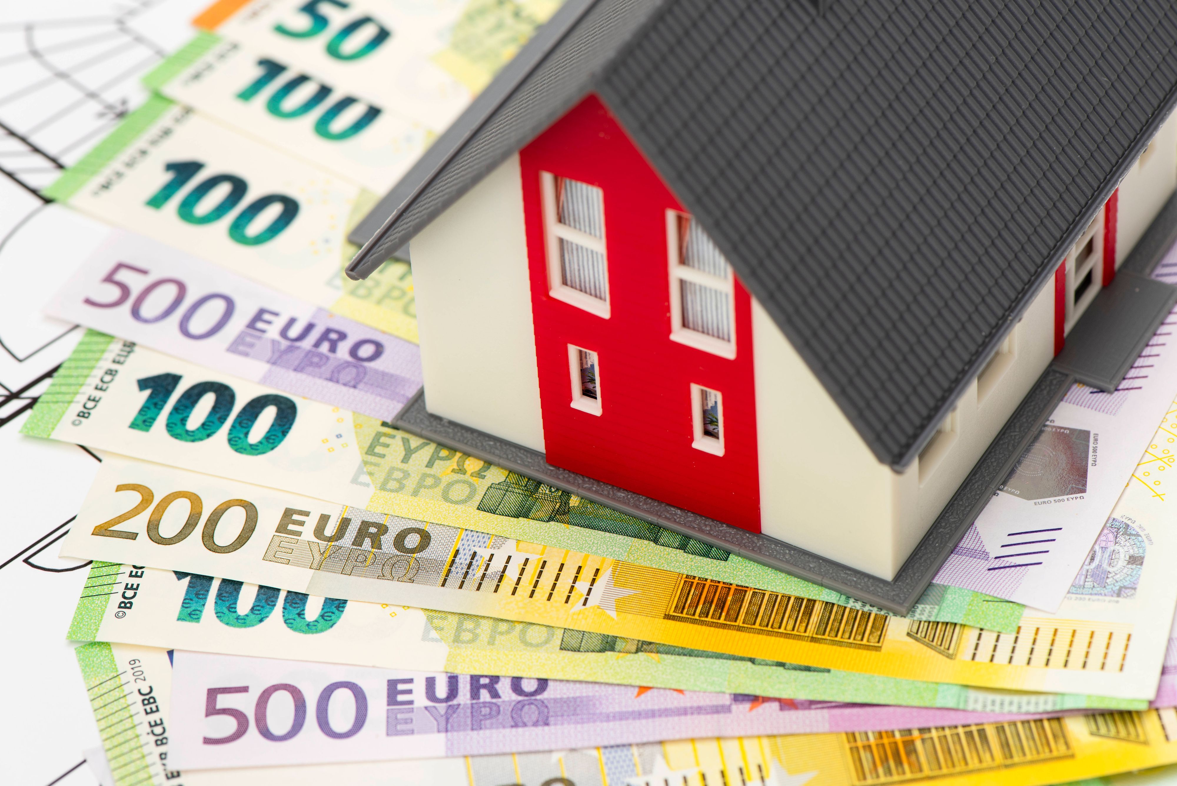Ein Modellhaus steht auf vielen Euro-Banknoten als Symbol für das Eigenheim, das nach Plänen der CDU zur Deckung der Pflegekosten herhalten könnte.