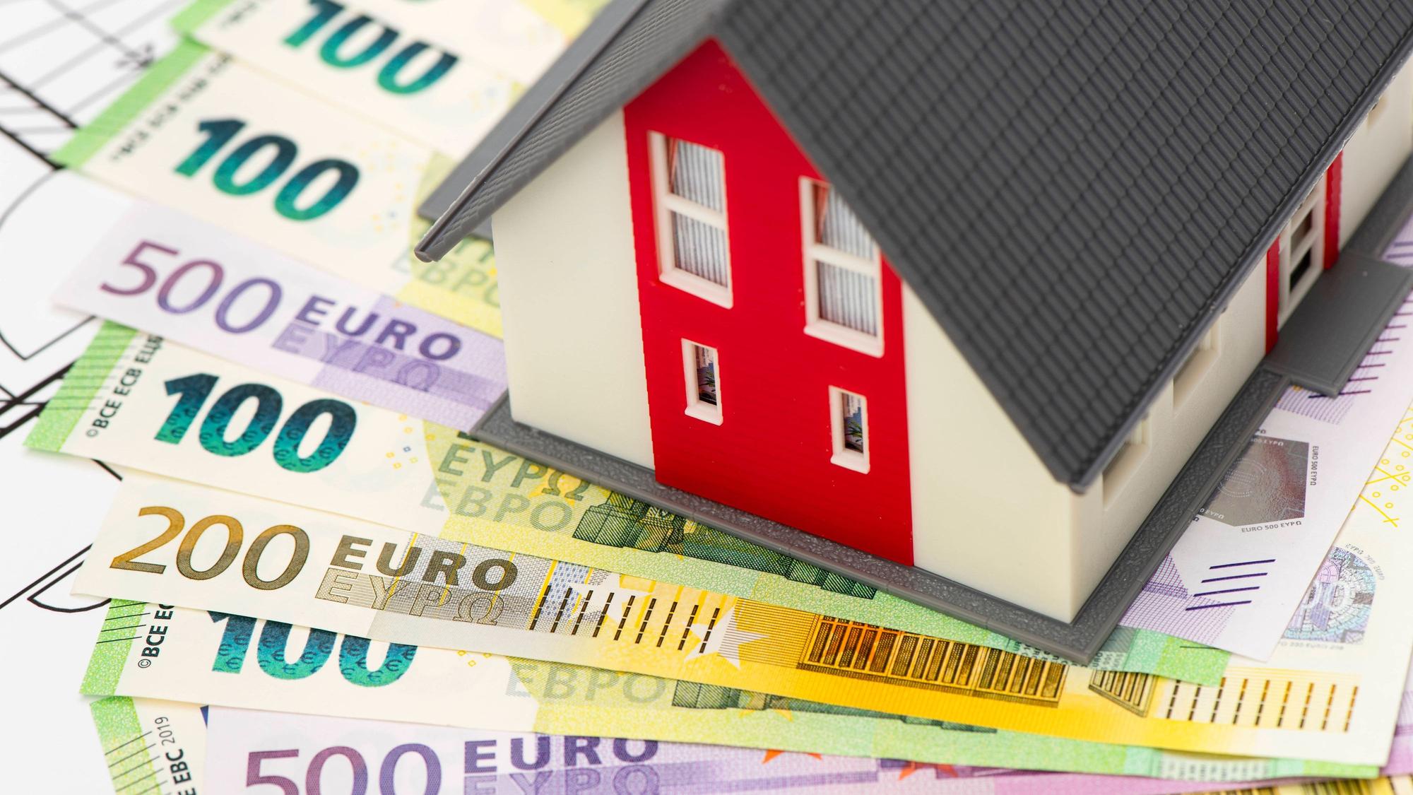 Ein Modellhaus steht auf vielen Euro-Banknoten als Symbol für das Eigenheim, das nach Plänen der CDU zur Deckung der Pflegekosten herhalten könnte.