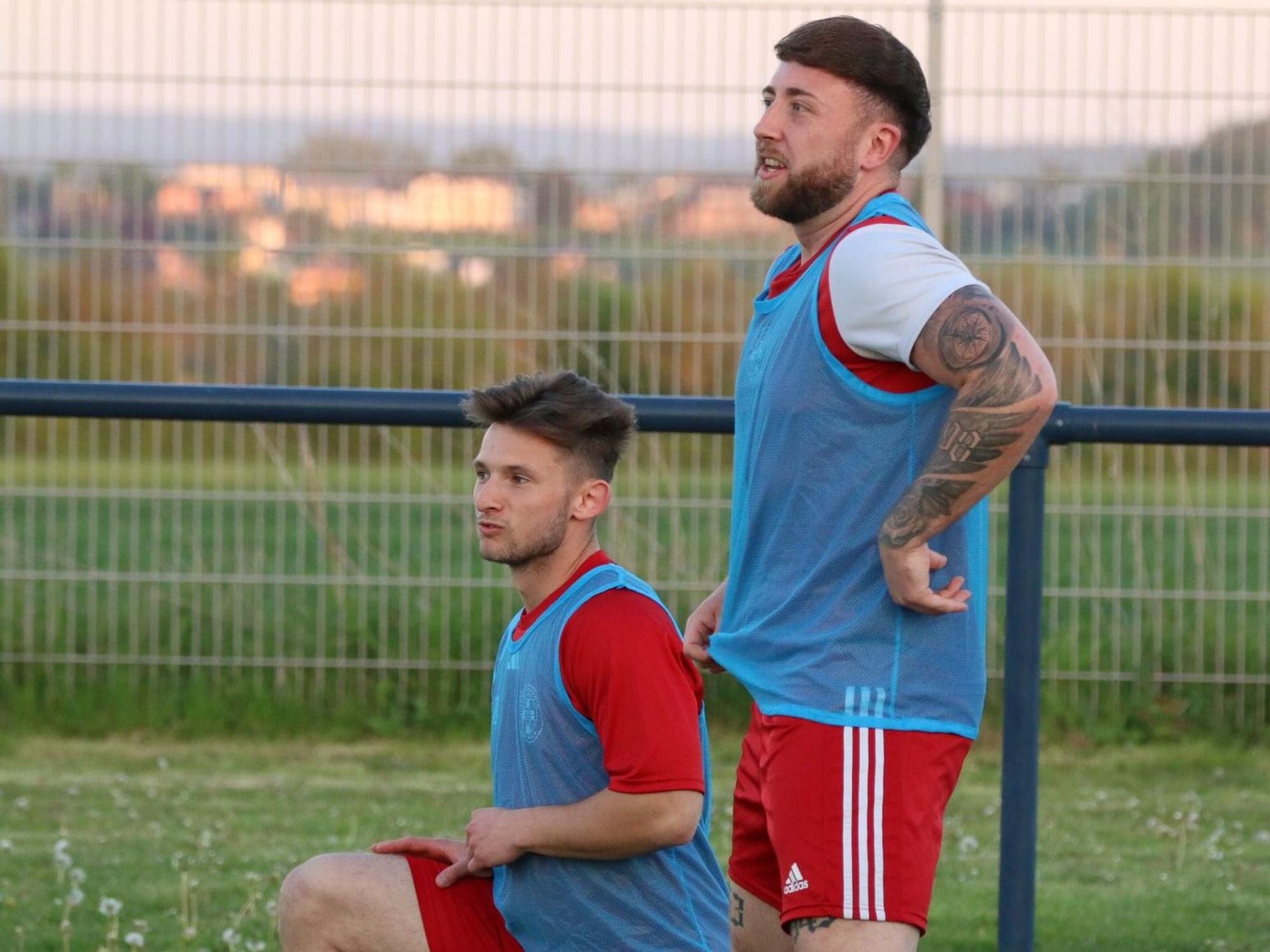Schauen beim Warmmachen den Kollegen zu: Devin Nickisch, der gerade hockend dehnt, und Nico Berekoven.