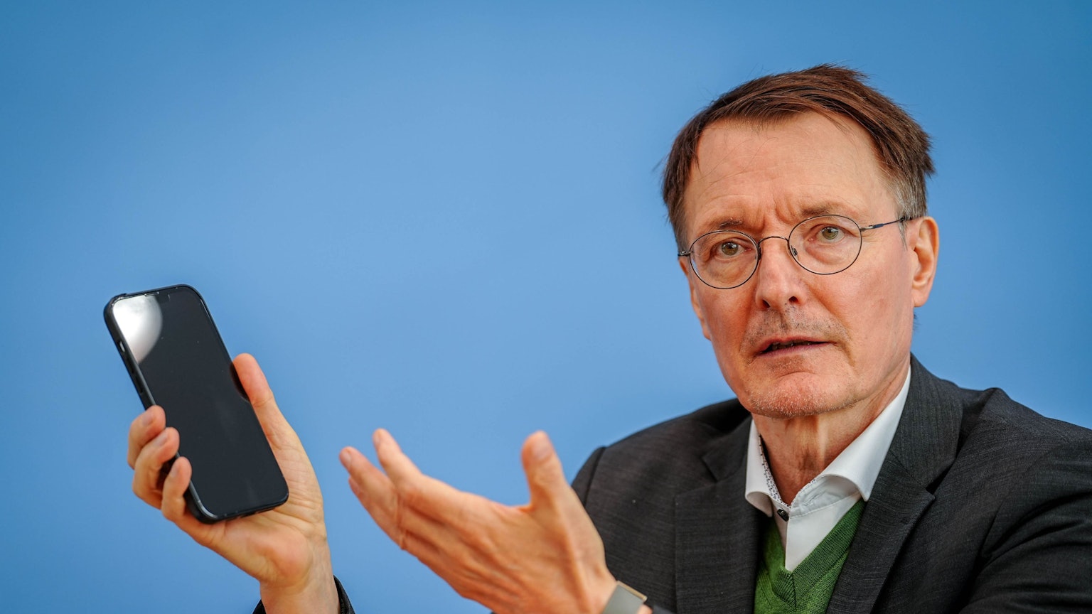 Der ehemalige Bundesgesundheitsminister Karl Lauterbach (SPD) mit einem Handy in der Hand. Der SPD-Politiker hat sich auf X zur Hitze und zum Klimawandel geäußert. (Archivbild)