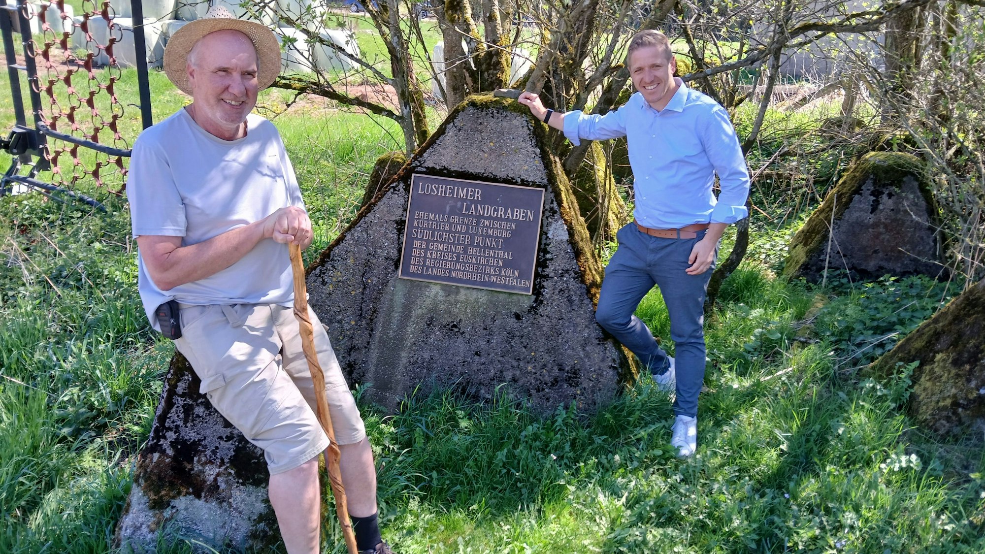 Ralf Spilles und Landrat Markus Ramers sind an der Erinnerungstafel an den Losheimer Landgraben zu sehen.