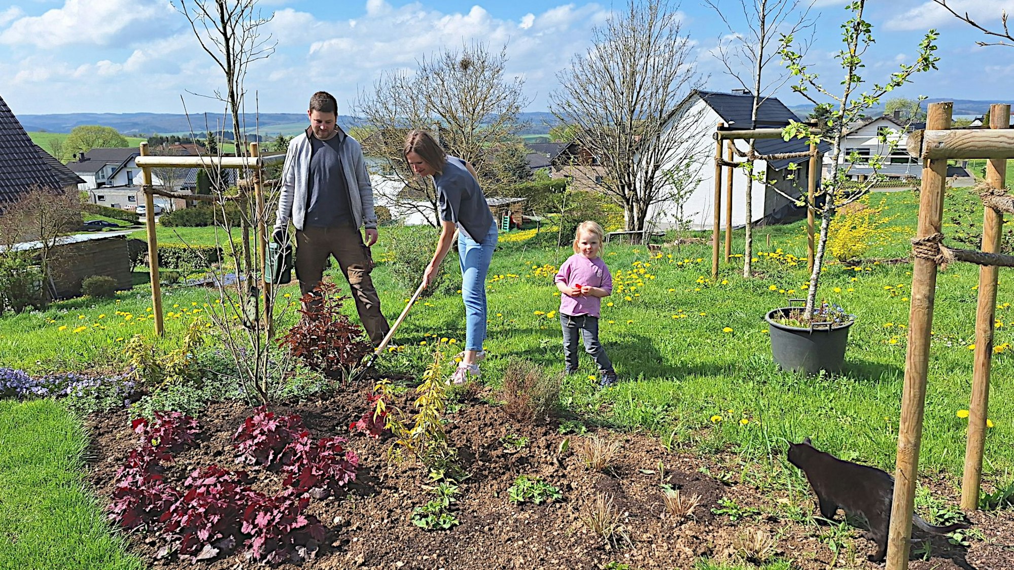 Das Ehepaar und deren Tochter stehen in ihrem Garten in Blankenheim-Lommersdorf und arbeiten in einem Beet.