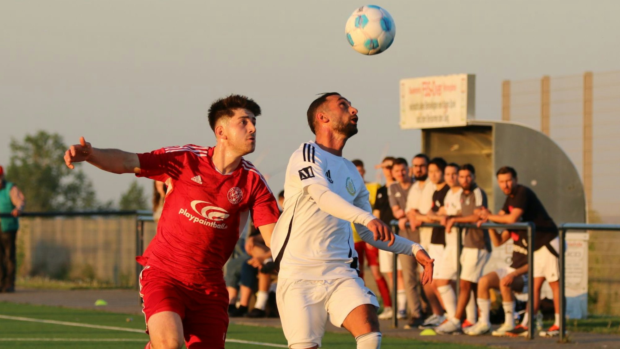 Burak Hendem schaut auf den Ball über ihm, Johannes Püllen nähert sich von hinten.
