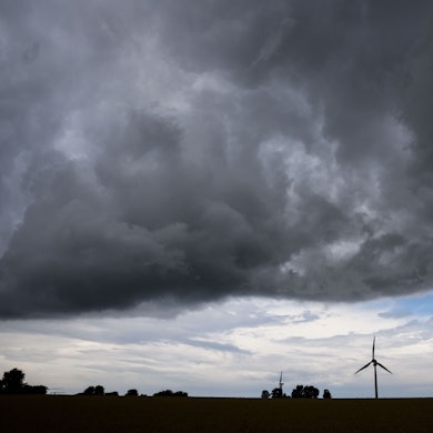 Eine Gewitterfront zieht über ein Windrad hinweg.