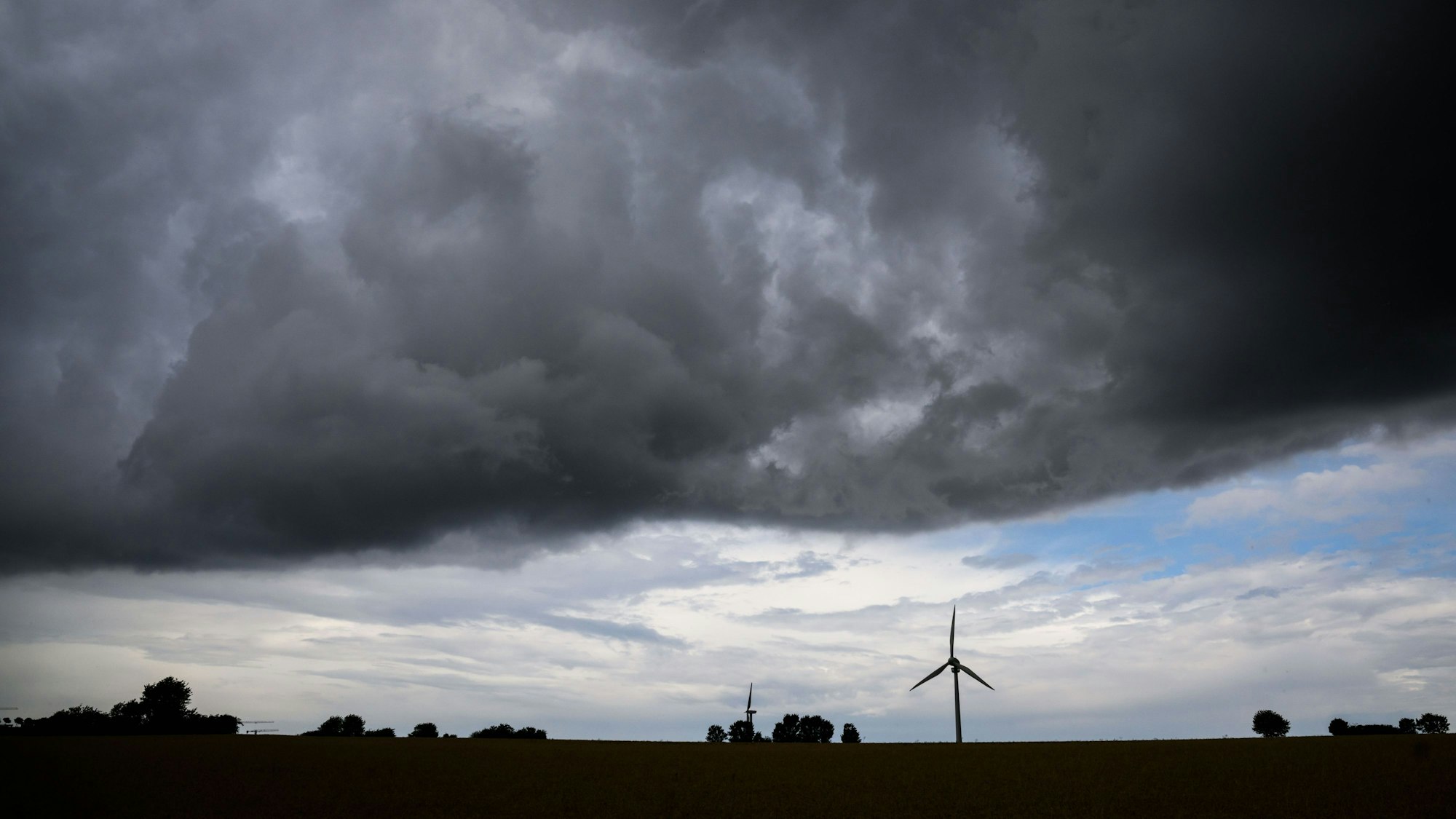 Eine Gewitterfront zieht über ein Windrad hinweg.
