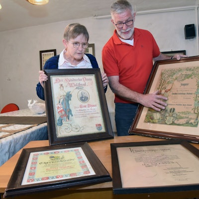 Ein Mann und eine Frau schauen sich alte Urkunden an.