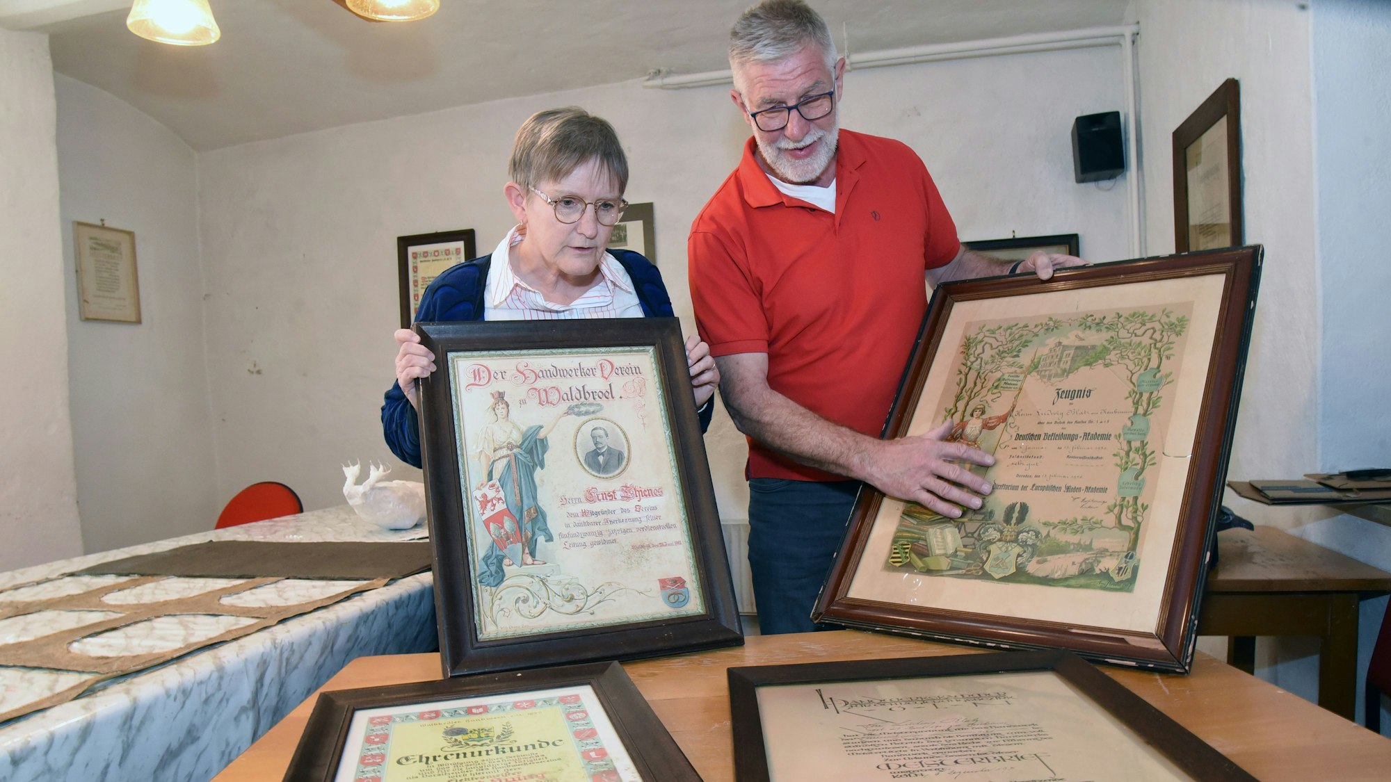 Ein Mann und eine Frau schauen sich alte Urkunden an.