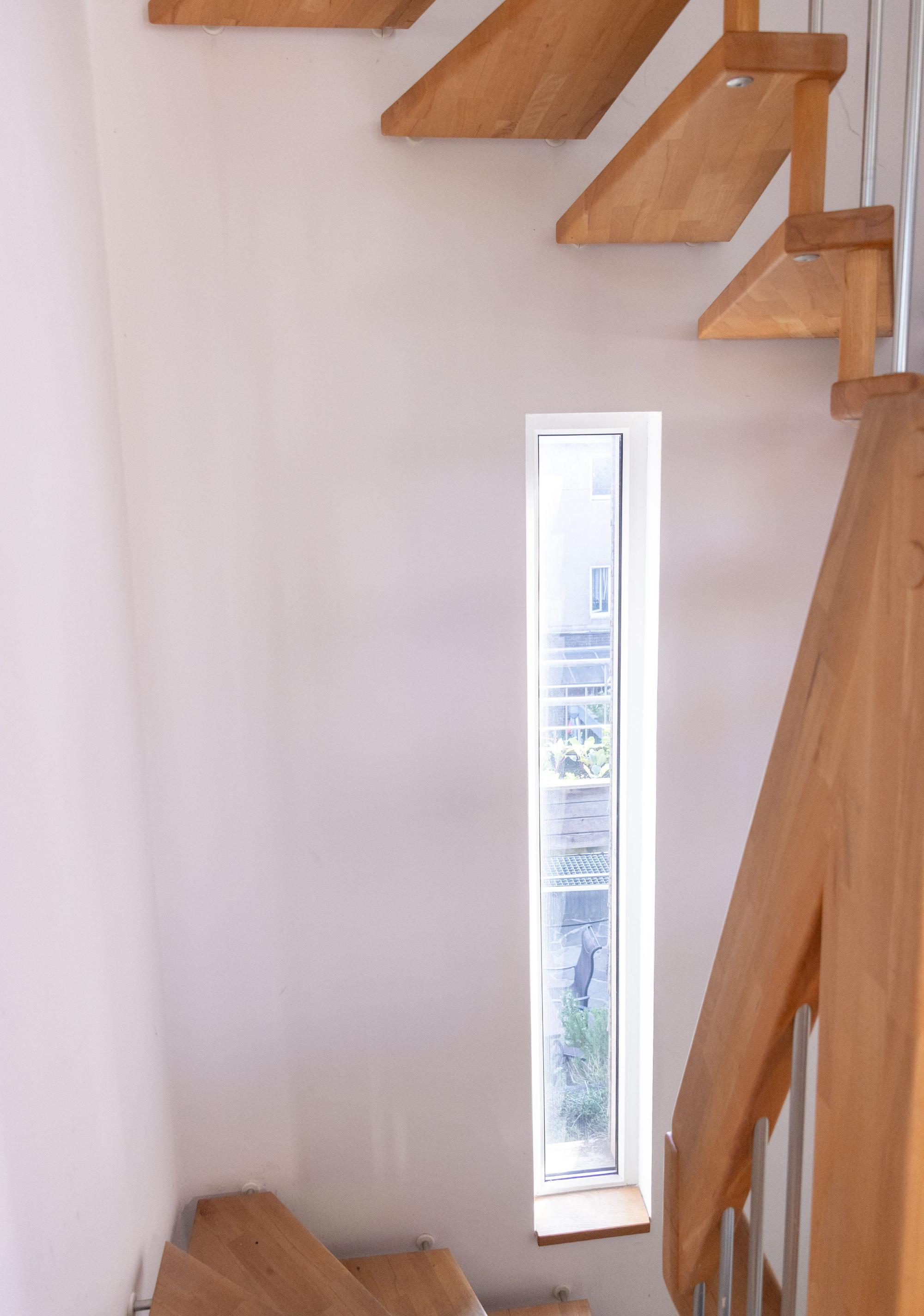 Blick in ein Treppenhaus mit schmalem Fensterschlitz