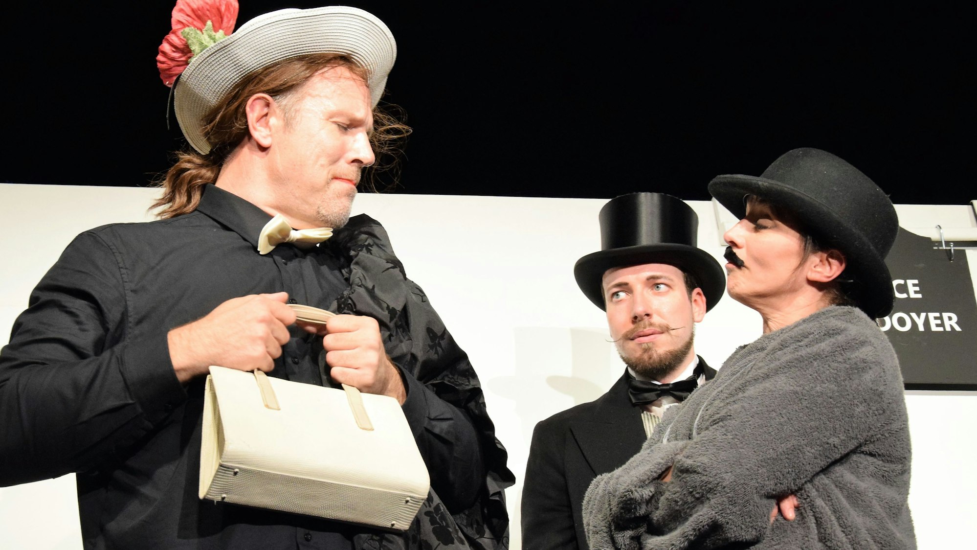 Das Bild zeigt drei Schauspieler bei einer Szene des Theaterstücks „Der Florentiner Hut“.