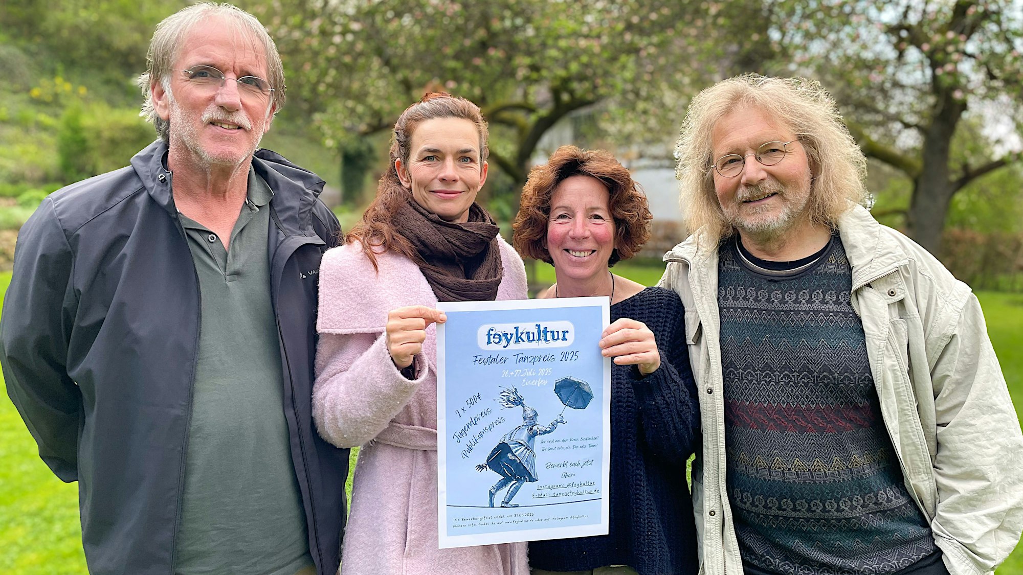 Vier von fünf Initiatoren der Feykultur stehen nebeneinander und halten das Plakat der Veranstaltung in die Kamera.