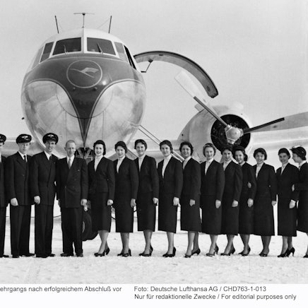 Nach dem Abschluss ihres Lehrgangs warten die ersten Flugbegleiterinnen und Flugbegleiter im Frühjahr 1955 vor einer Convair-Maschine auf ihren Einsatz.