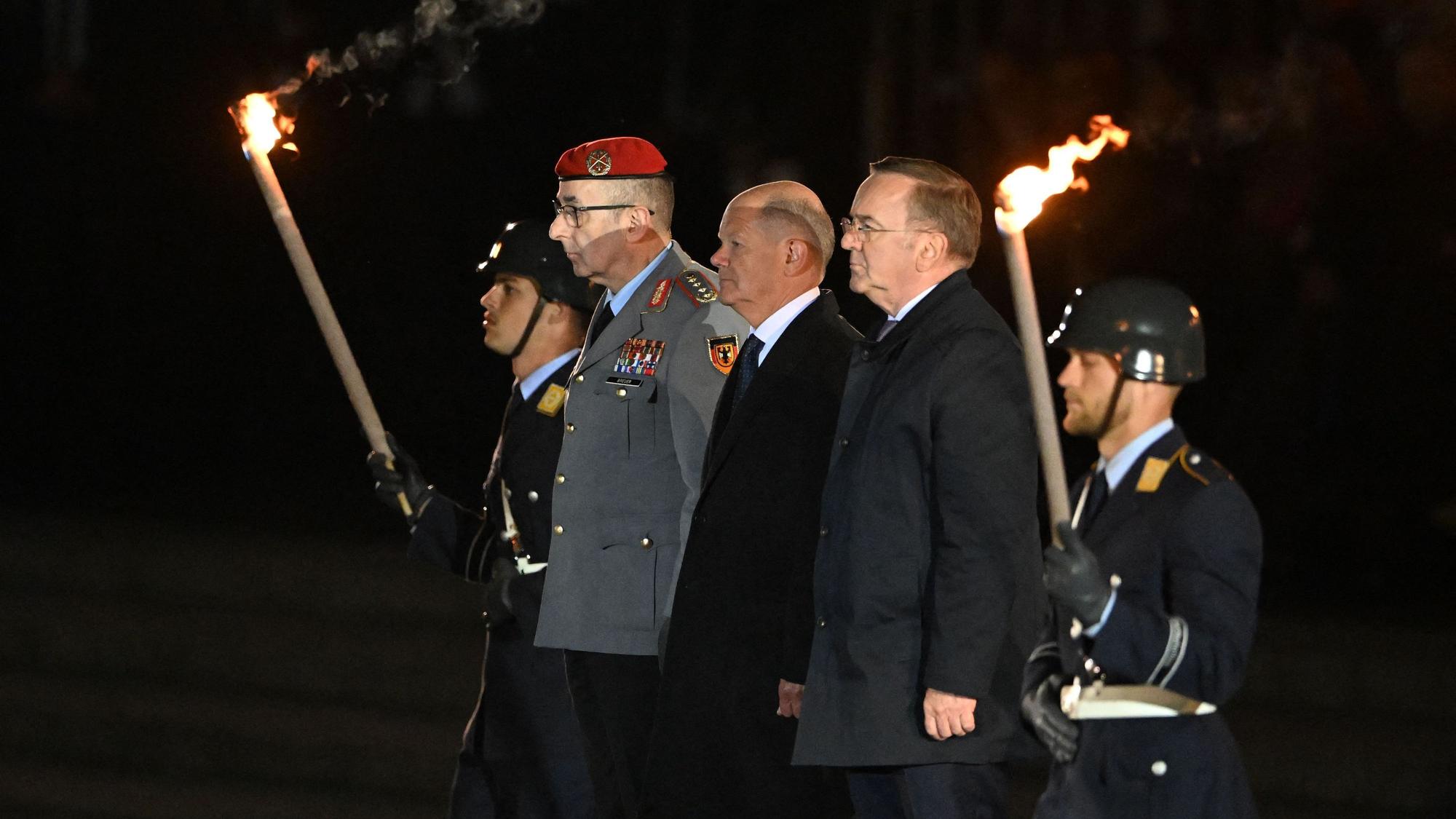 German Chancellor Olaf Scholz (C) flanked by German Defence Minister Boris Pistorius (R) and the General of the German Armed Forces Bundeswehr Carsten Breuer (R) arrive at the Defence Ministry to attend the Grand Tattoo (Grosser Zapfenstreich), a ceremonial send-off for outgoing German Chancellor in Berlin on May 5, 2025. (Photo by RALF HIRSCHBERGER / AFP)