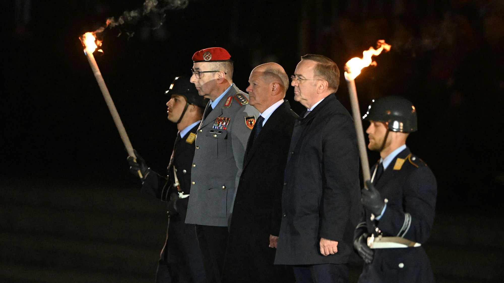 German Chancellor Olaf Scholz (C) flanked by German Defence Minister Boris Pistorius (R) and the General of the German Armed Forces Bundeswehr Carsten Breuer (R) arrive at the Defence Ministry to attend the Grand Tattoo (Grosser Zapfenstreich), a ceremonial send-off for outgoing German Chancellor in Berlin on May 5, 2025. (Photo by RALF HIRSCHBERGER / AFP)