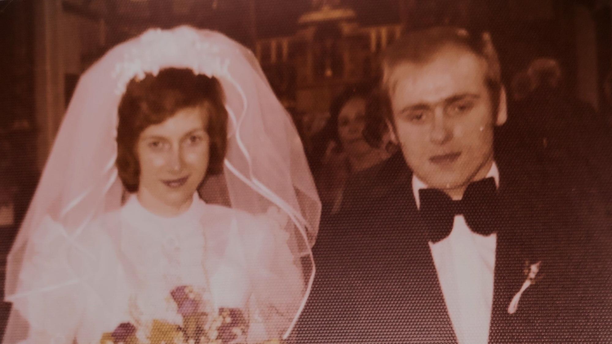 Das Foto zeigt ein Ehepaar bei der Hochzeit.