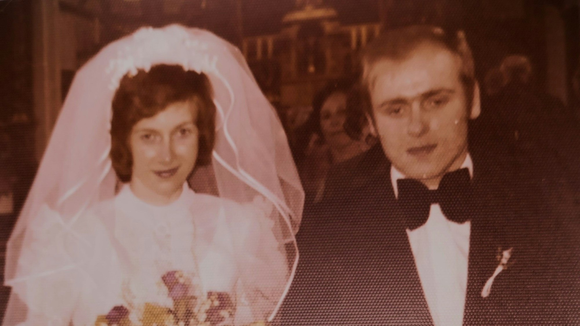 Das Foto zeigt ein Ehepaar bei der Hochzeit.