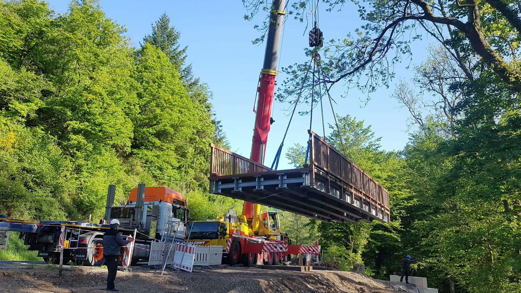 Eine Brücke hängt an einem hohen Kran.