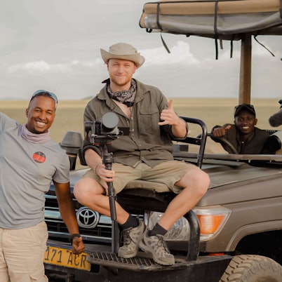 Männer sitzen auf einem Geländewagen in Tansania.