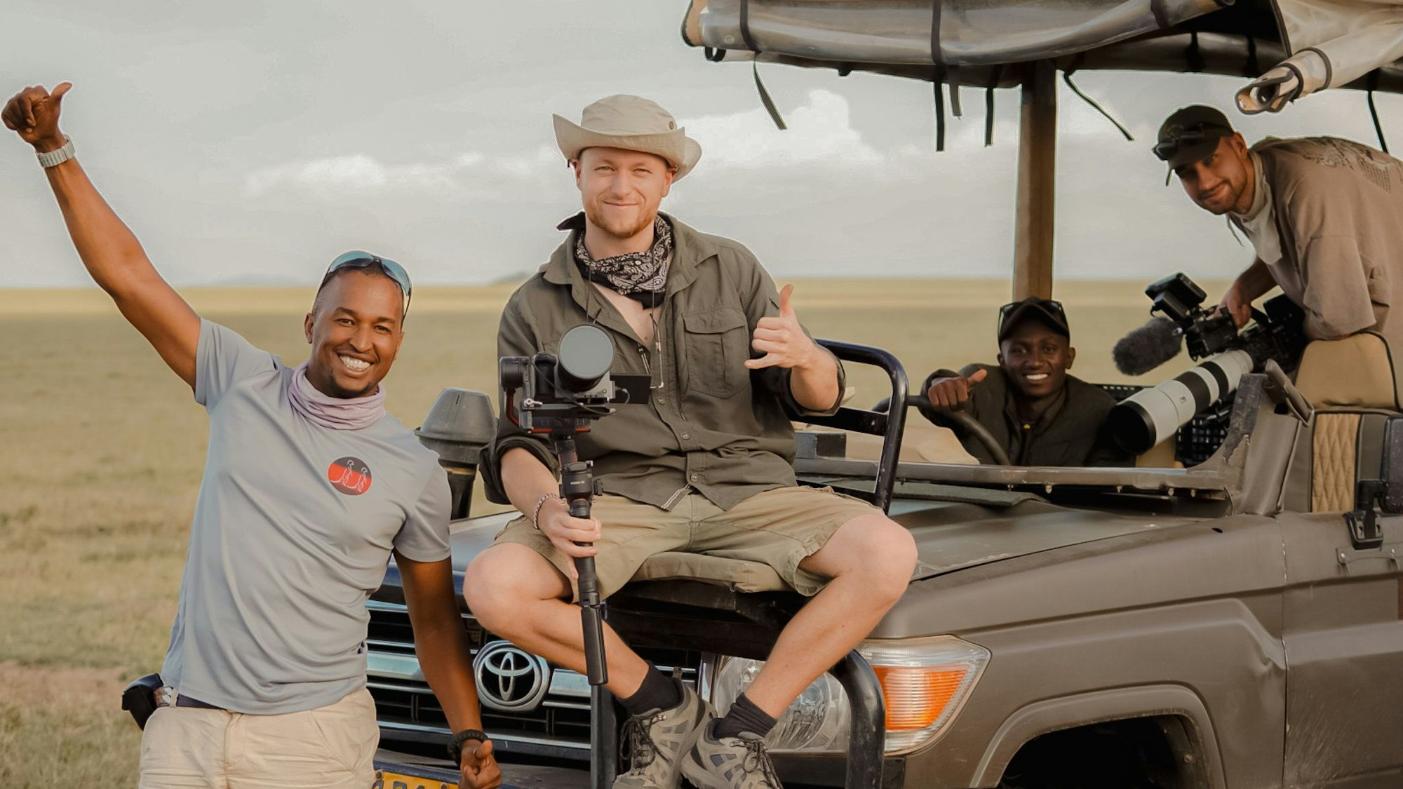 Männer sitzen auf einem Geländewagen in Tansania.