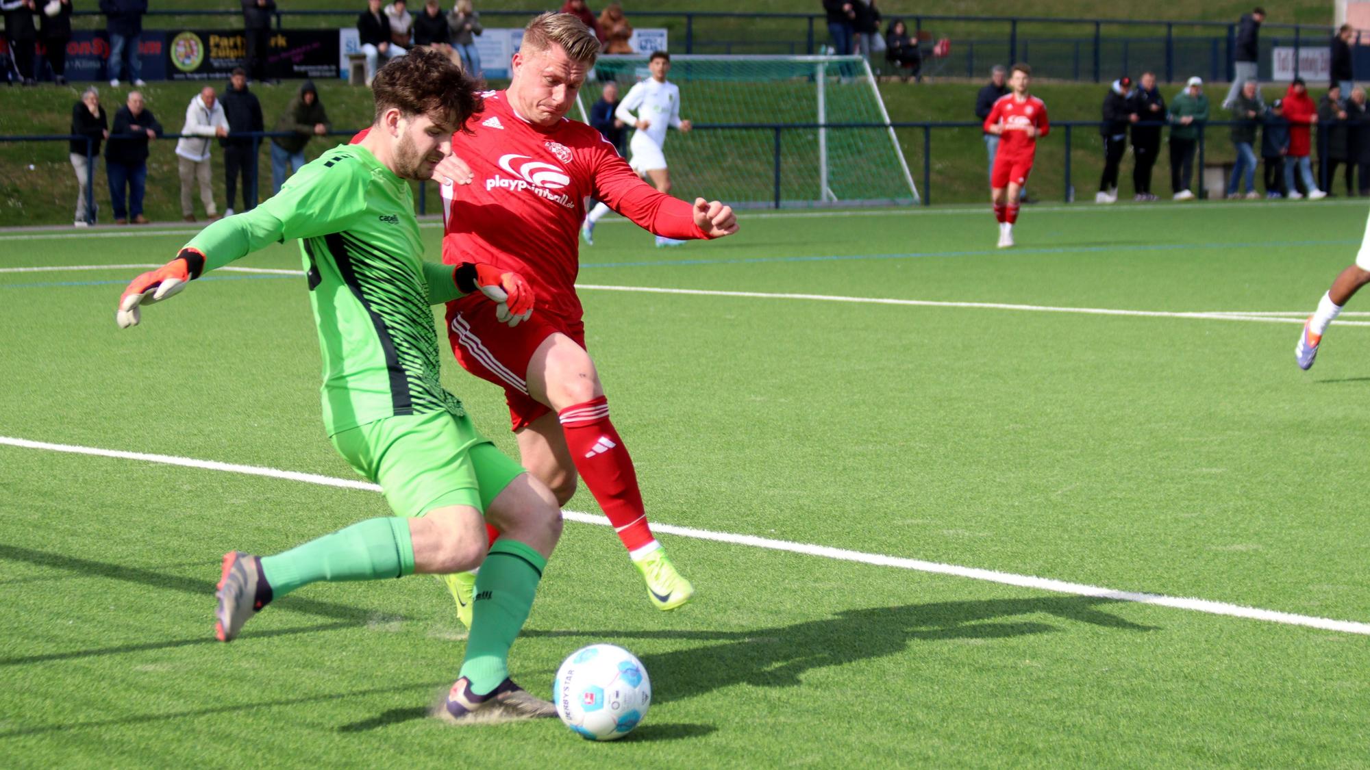 Zülpichs Stürmer Marvin Iskra im Duell mit dem Torhüter des 1. FC Düren II.