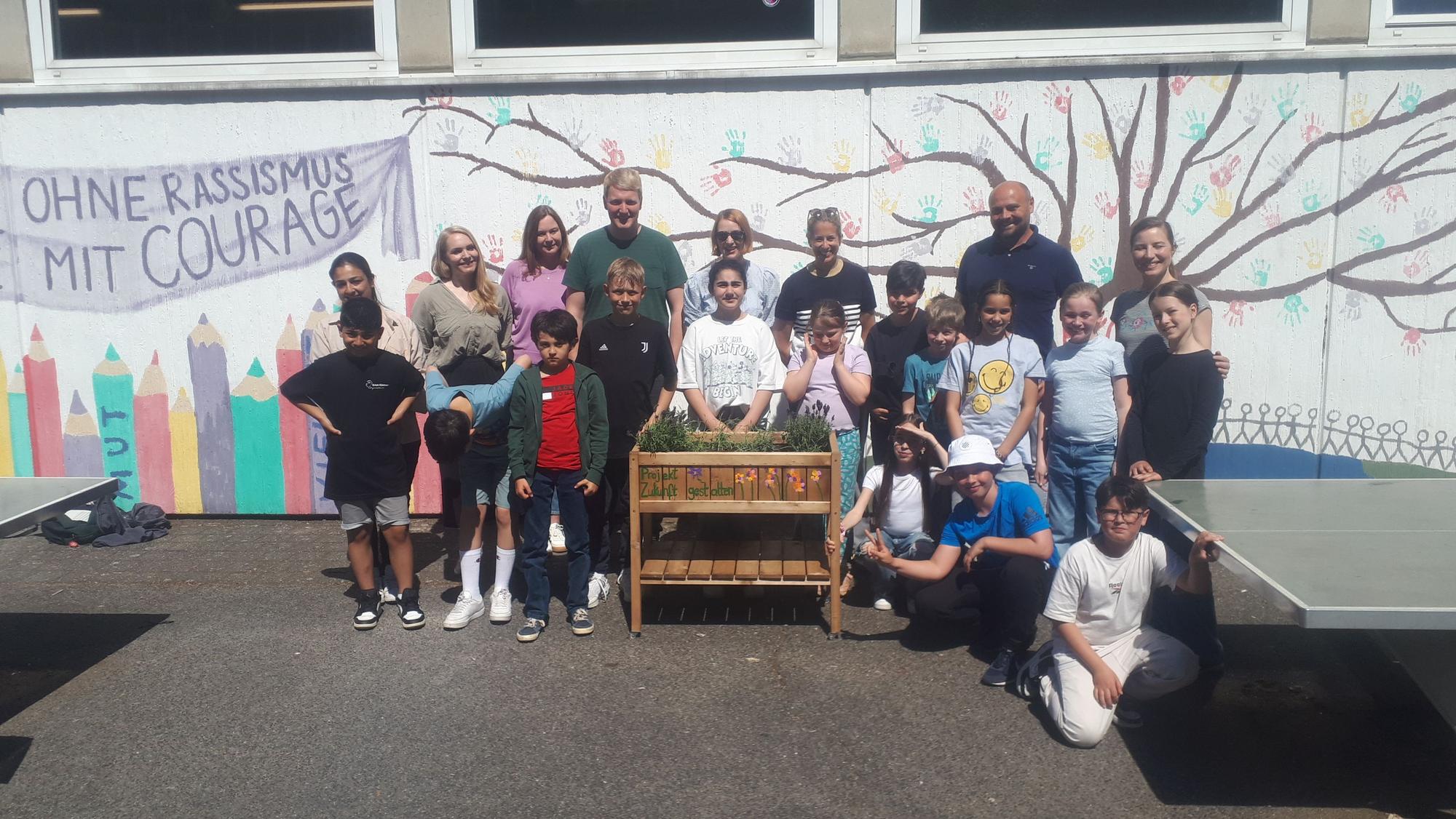 Die Schülerinnen und Schüler, Lehrkräfte sowie Schulleiter Bohdan Zemek (5.v.r.) vor dem selbstgebauten Lavendel-Hochbeet.