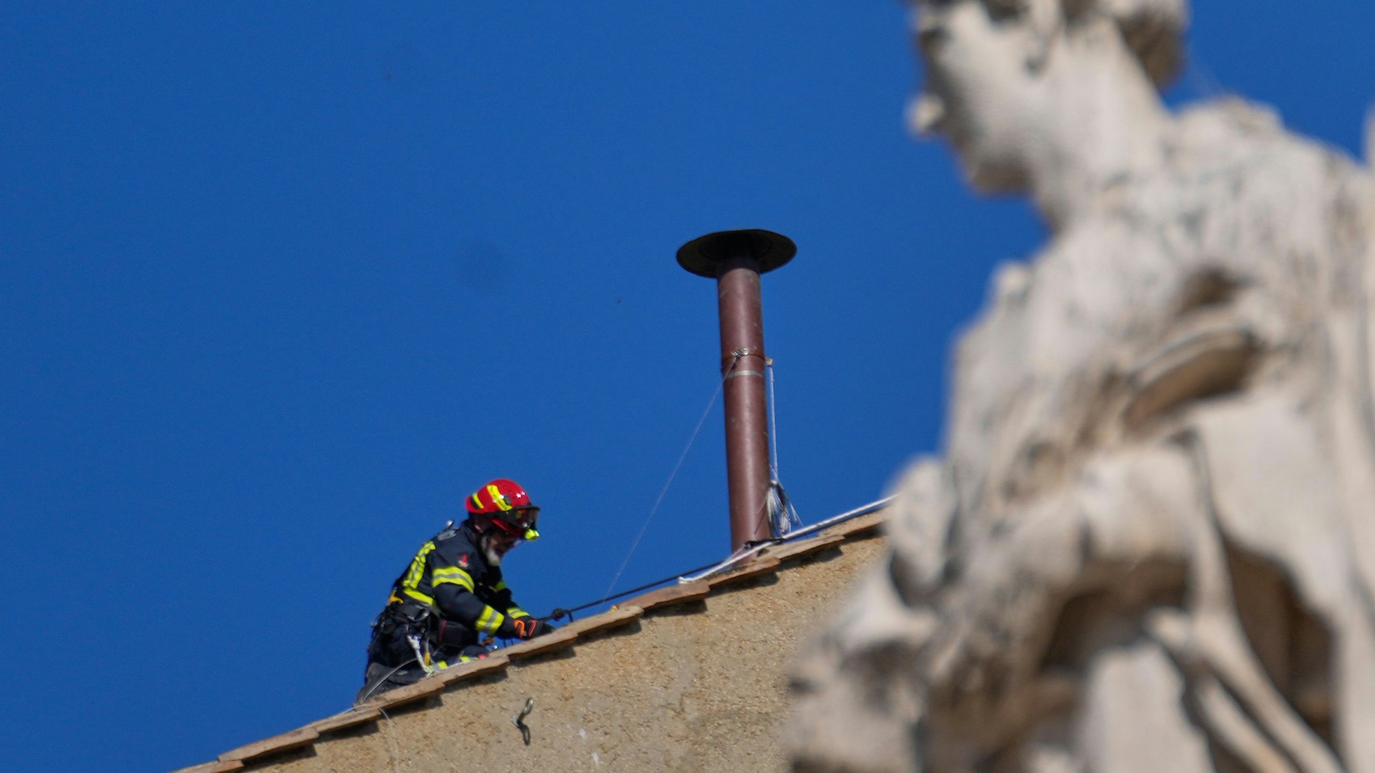 Feuerwehrleute platzieren den Schornstein auf dem Dach der Sixtinischen Kapelle, wo sich die Kardinäle zur Wahl des neuen Papstes versammeln werden.