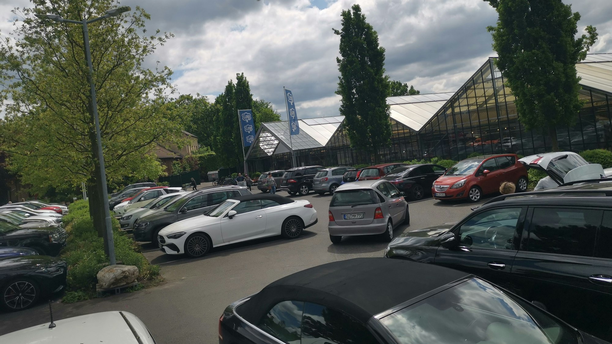 Blick auf den Parkplatz und die große Halle des Gartencenters Ley.