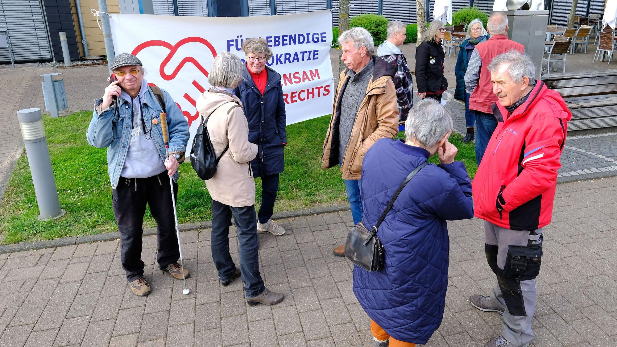 Frauen und Männer haben sich vor einem Banner am Rathaus in Mechernich versammelt.