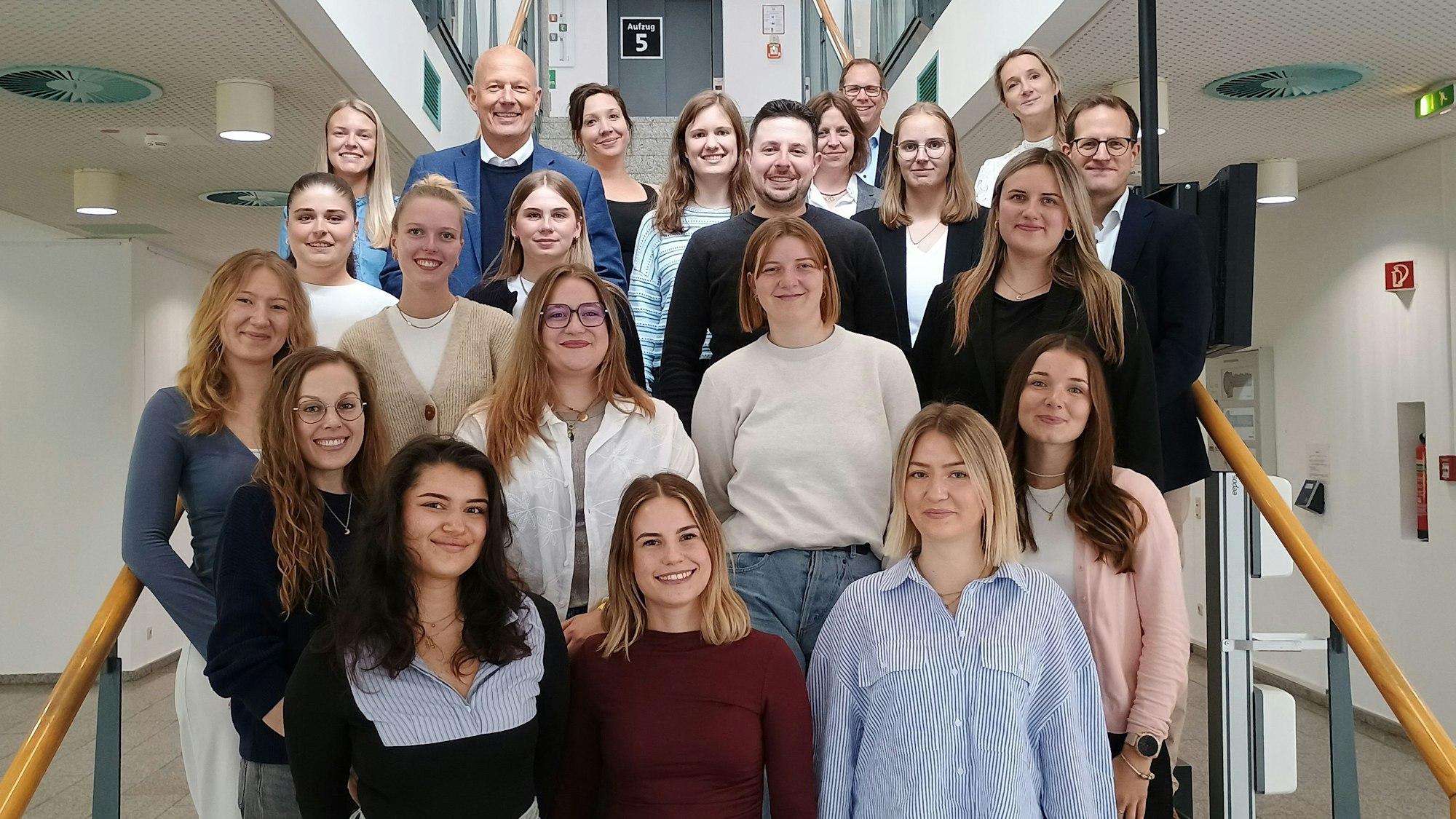 Die Studierenden stehen für ein Gruppenfoto mit Landrat Frank Rock und den Mitarbeitenden den Bildungsbüros Rhein Erft auf einer Treppe im Kreishaus.