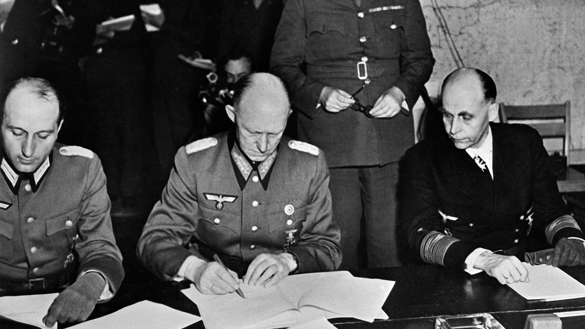 (FILES) German General Alfred Jodl (C), flanked by German Admiral Hans-Georg von Friedeburg (R) and German Major Wilhelm Oxenius (L), and Major-General Kenneth Strong of the British Army standing behind them, signs the act of unconditional surrender of Nazi Germany that ends the Second World War in Europe, at the Allied headquarters in Reims, eastern France, on May 7, 1945. The 80th anniversary of the end of World War II in Europe will be commemorated on May 8, 2025. (Photo by AFP)