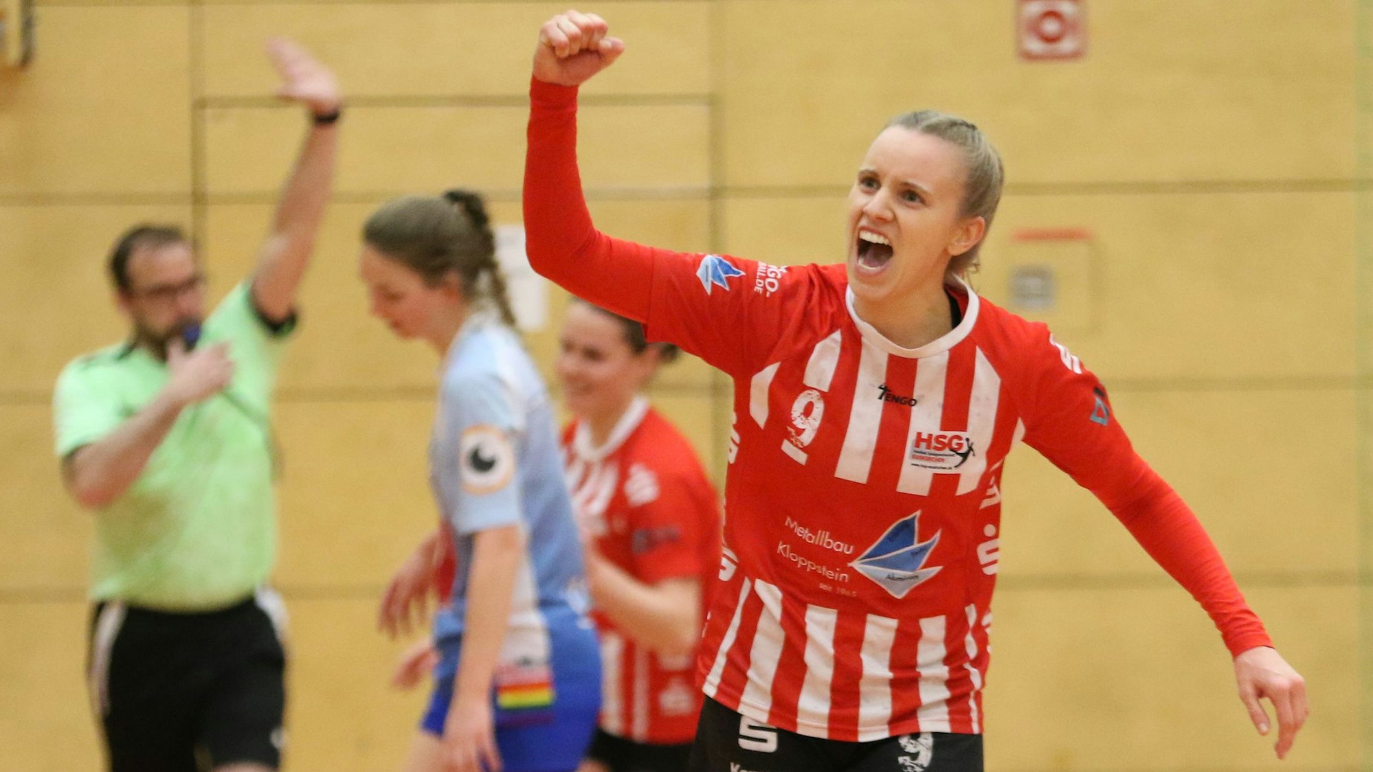 Handballerin Corinna Schmitz trägt das rot-weiße Trikot der HSG Euskirchen und bejubelt mit erhobener Faust ein Tor.