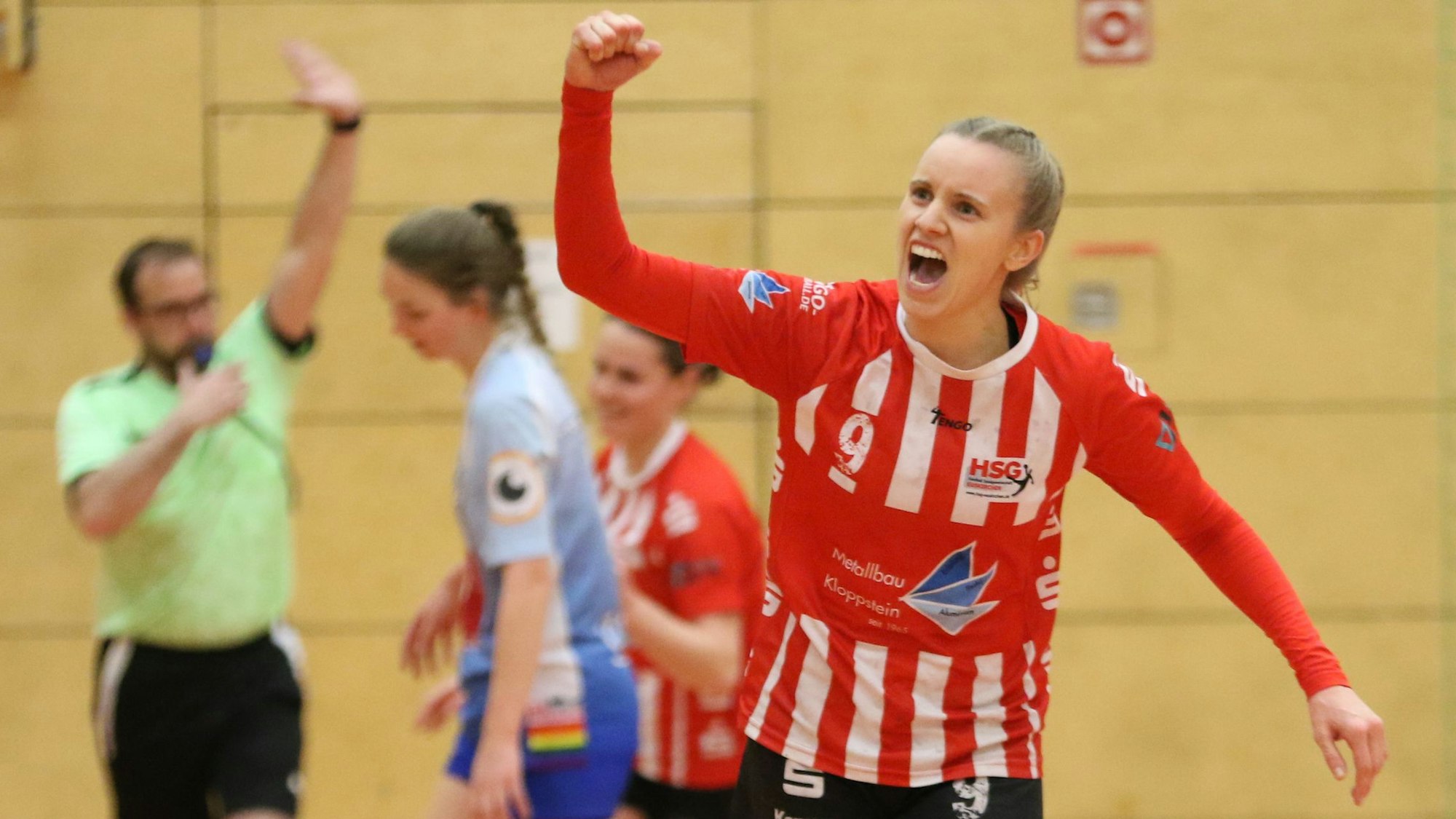 Handballerin Corinna Schmitz trägt das rot-weiße Trikot der HSG Euskirchen und bejubelt mit erhobener Faust ein Tor.