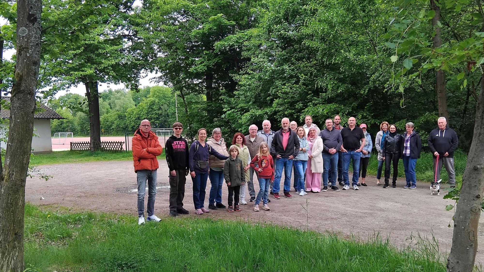 Menschen stehen auf dem Parkplatz eines Sportplatzes