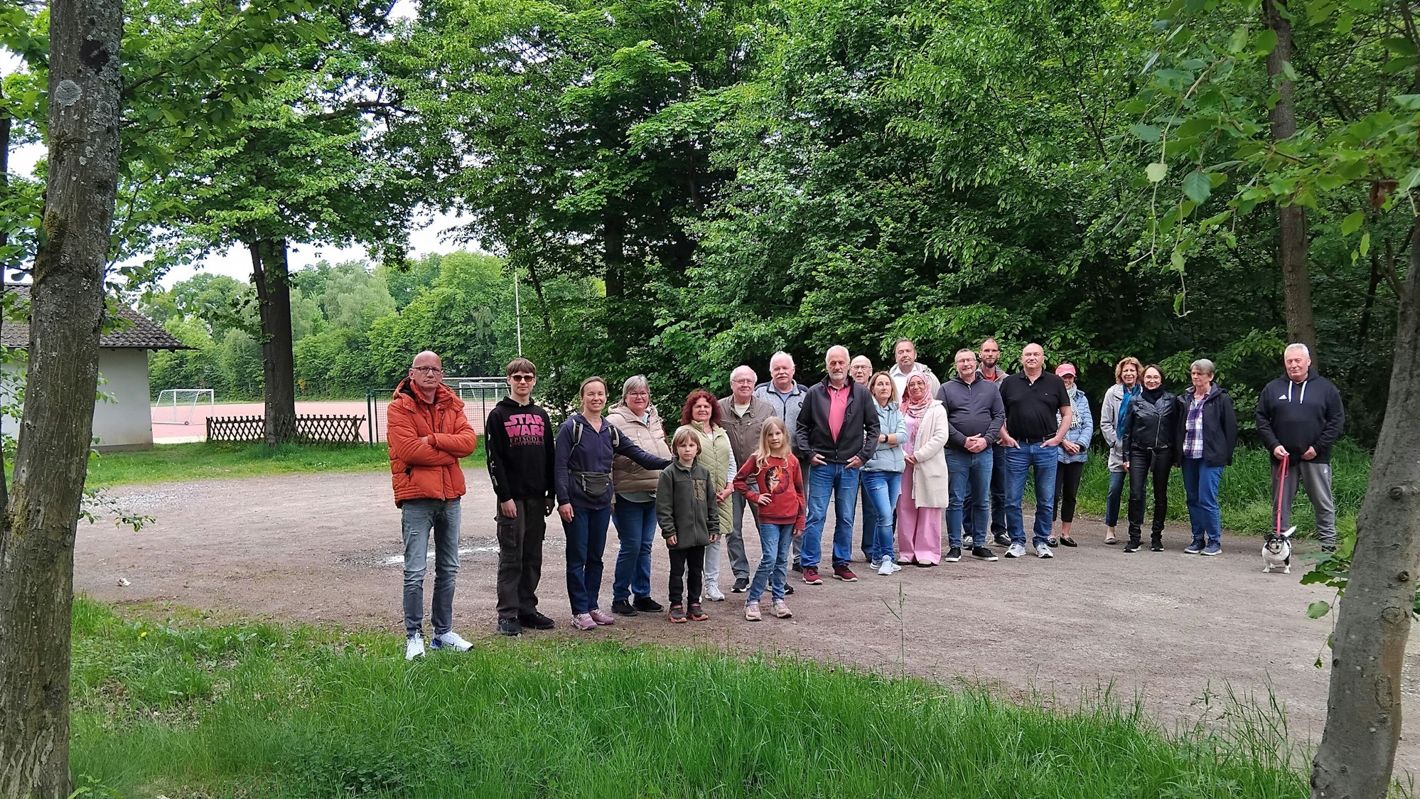 Menschen stehen auf dem Parkplatz eines Sportplatzes
