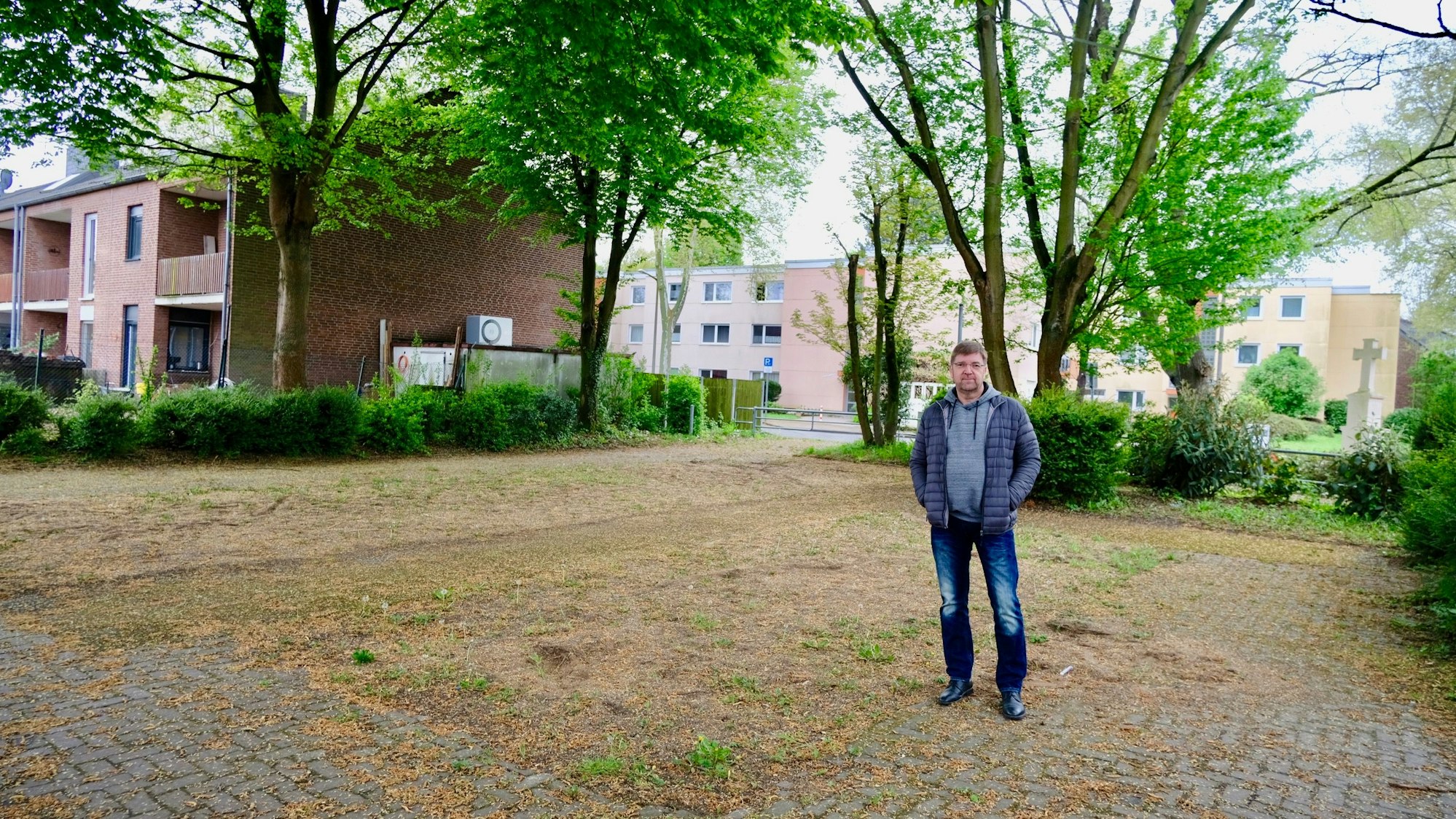 Ein Mann steht auf einem leeren Spielplatz an der Ostlandstraße, Ecke Schulstraße.