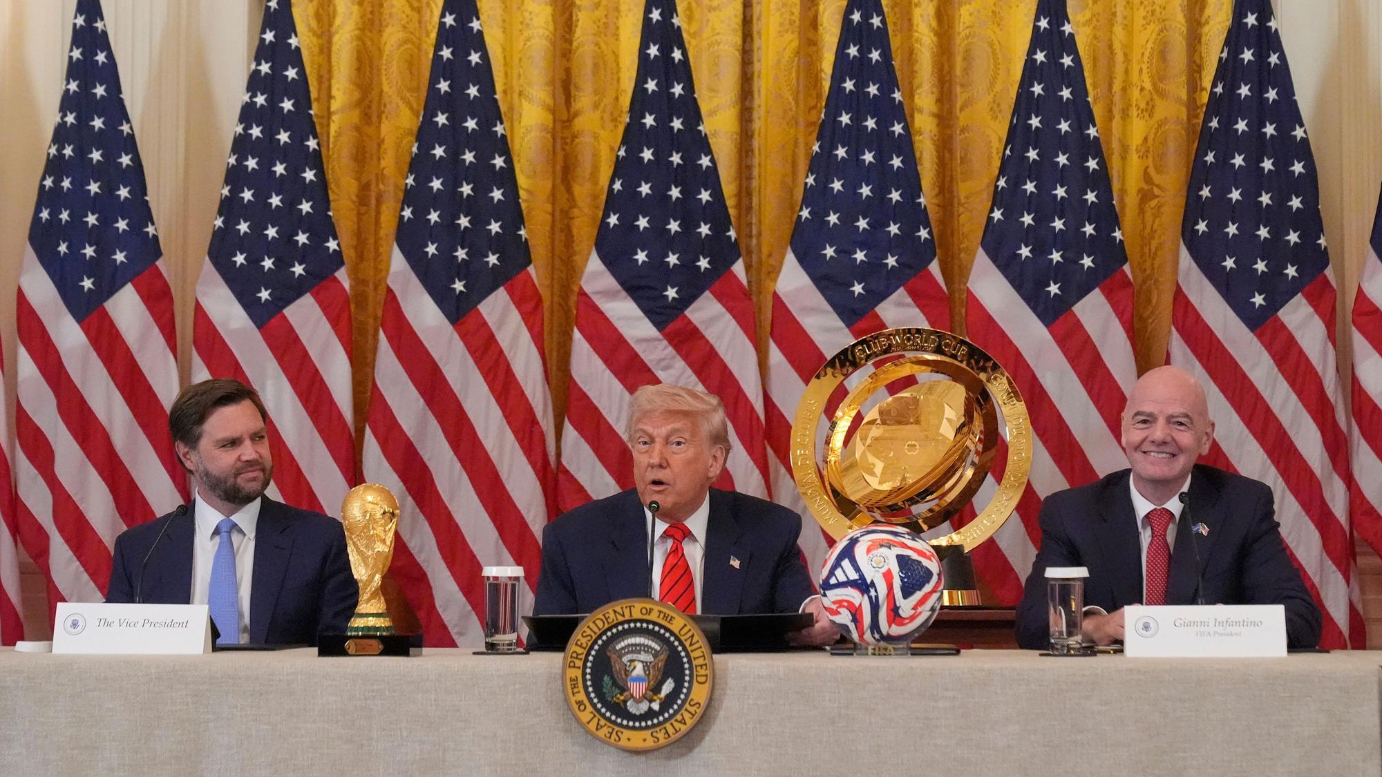 06.05.2025, USA, Washington: US-Präsident Donald Trump (M) spricht während einer Sitzung der FIFA-Task Force im East Room des Weißen Hauses während US_Vizepräsident JD Vance und FIFA-Präsident Gianni Infantino (r) zuhören. Foto: Mark Schiefelbein/AP/dpa +++ dpa-Bildfunk +++