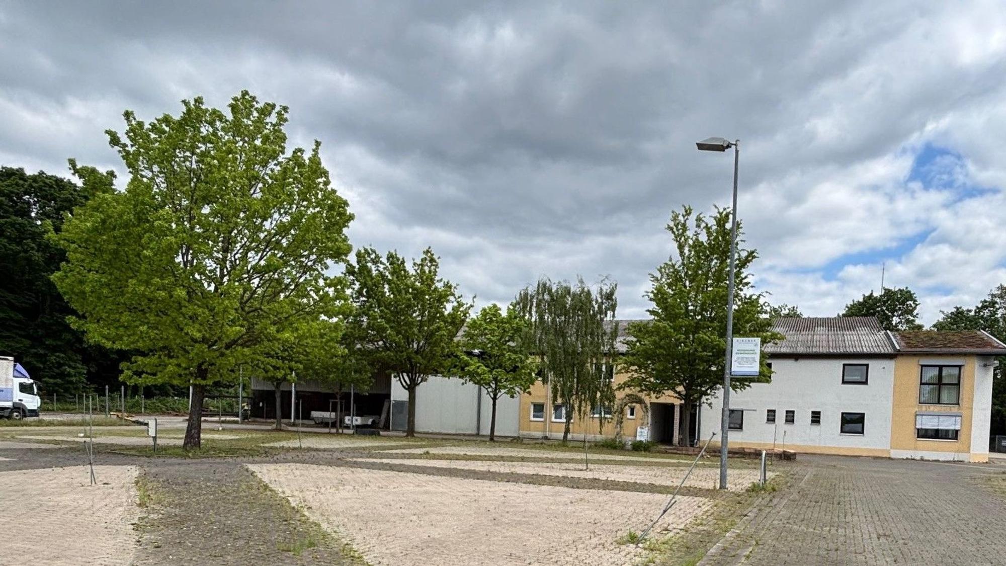 Auf dem Bild ist ein Teil des Zirener-Grundstücks mit Bäumen und dem Bürogebäude zu sehen.