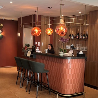 Eine Frau steht hinter der Rezeption im Eingangsbereich eines Hotels.