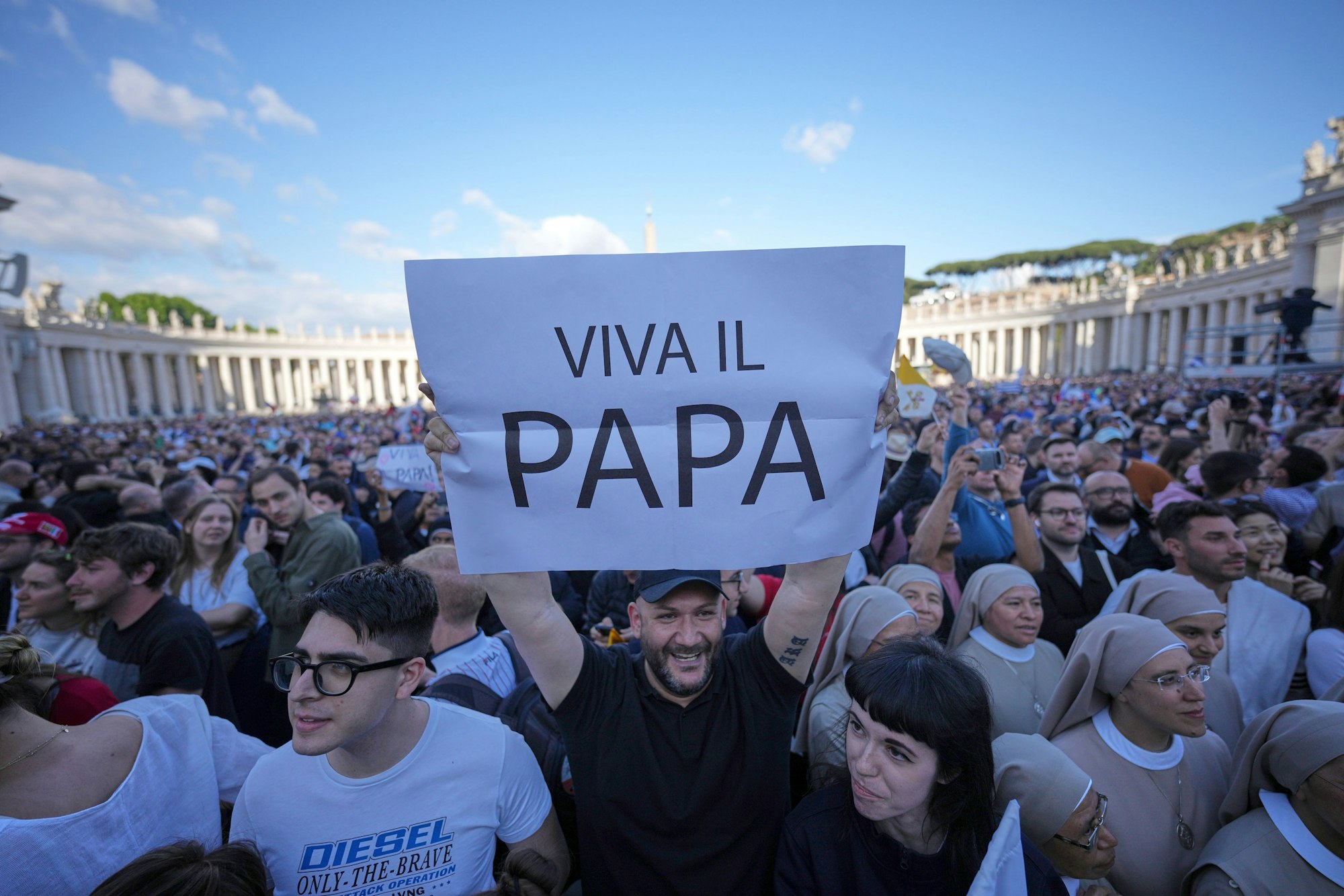 Das Foto zeigt Gläubige wie sie ein Transparent mit der Aufschrift «Viva Il Papa» in die Höhe halten, nachdem weißer Rauch aus dem Schornstein der Sixtinischen Kapelle aufsteigt. Foto: Andrew Medichini/AP/dpa
