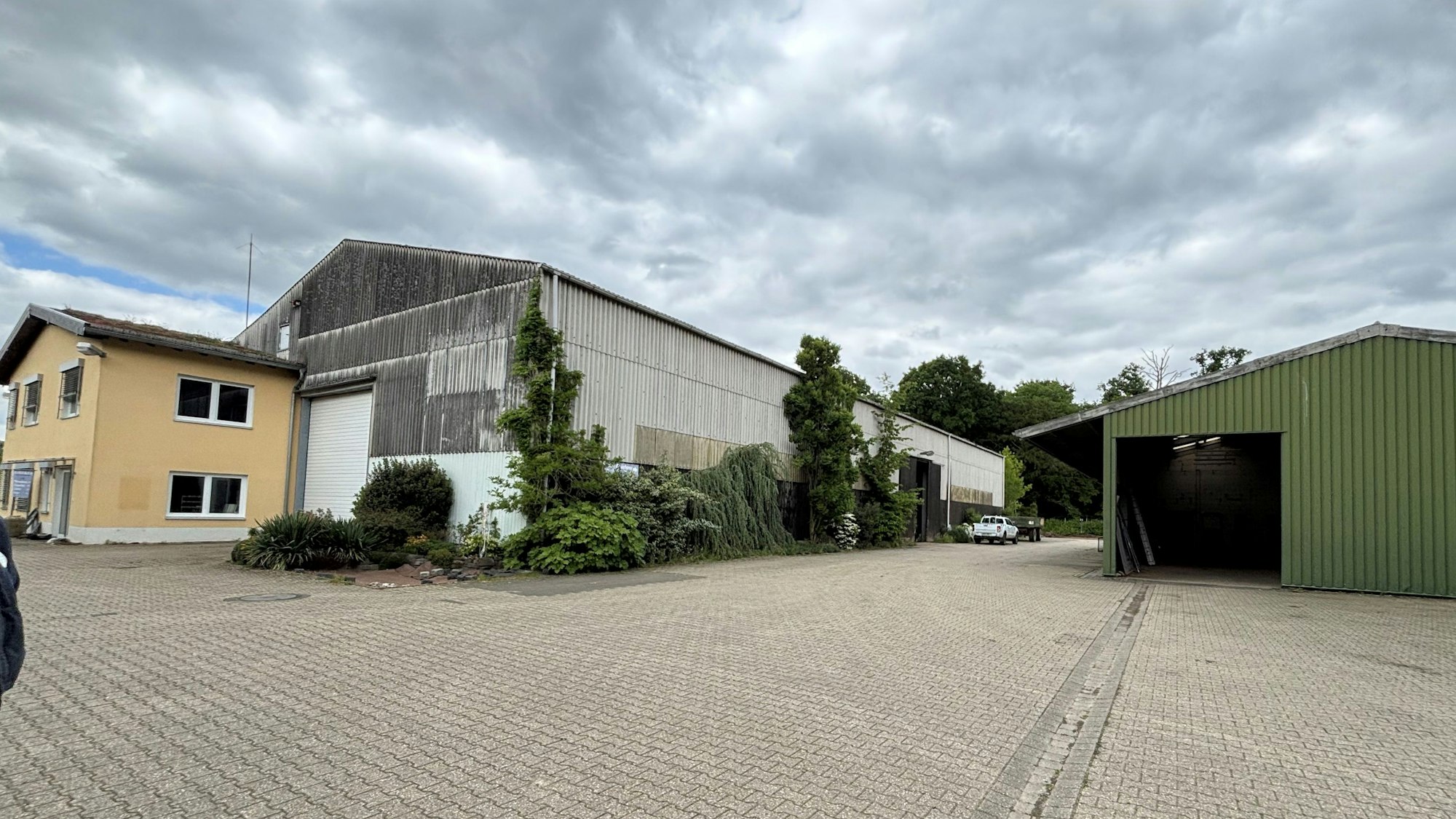 Auf dem Bild sind Firmengebäude und Hallen des ehemaligen Gartenbaubetriebs Zirener zu sehen.