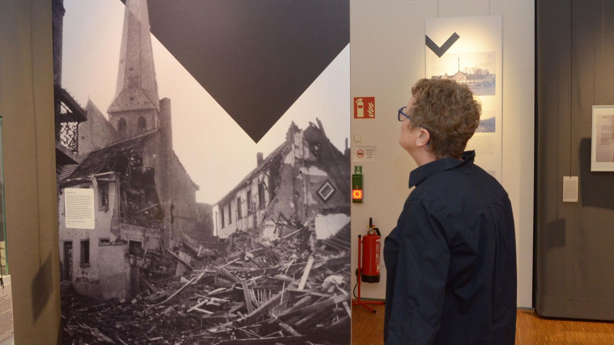 Eine Frau schaut sich im Museum ein Schwarz-Weiß-Foto an.